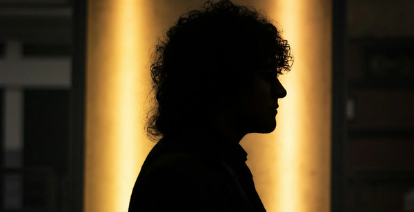 A blackout image of a woman on a yellow and background 